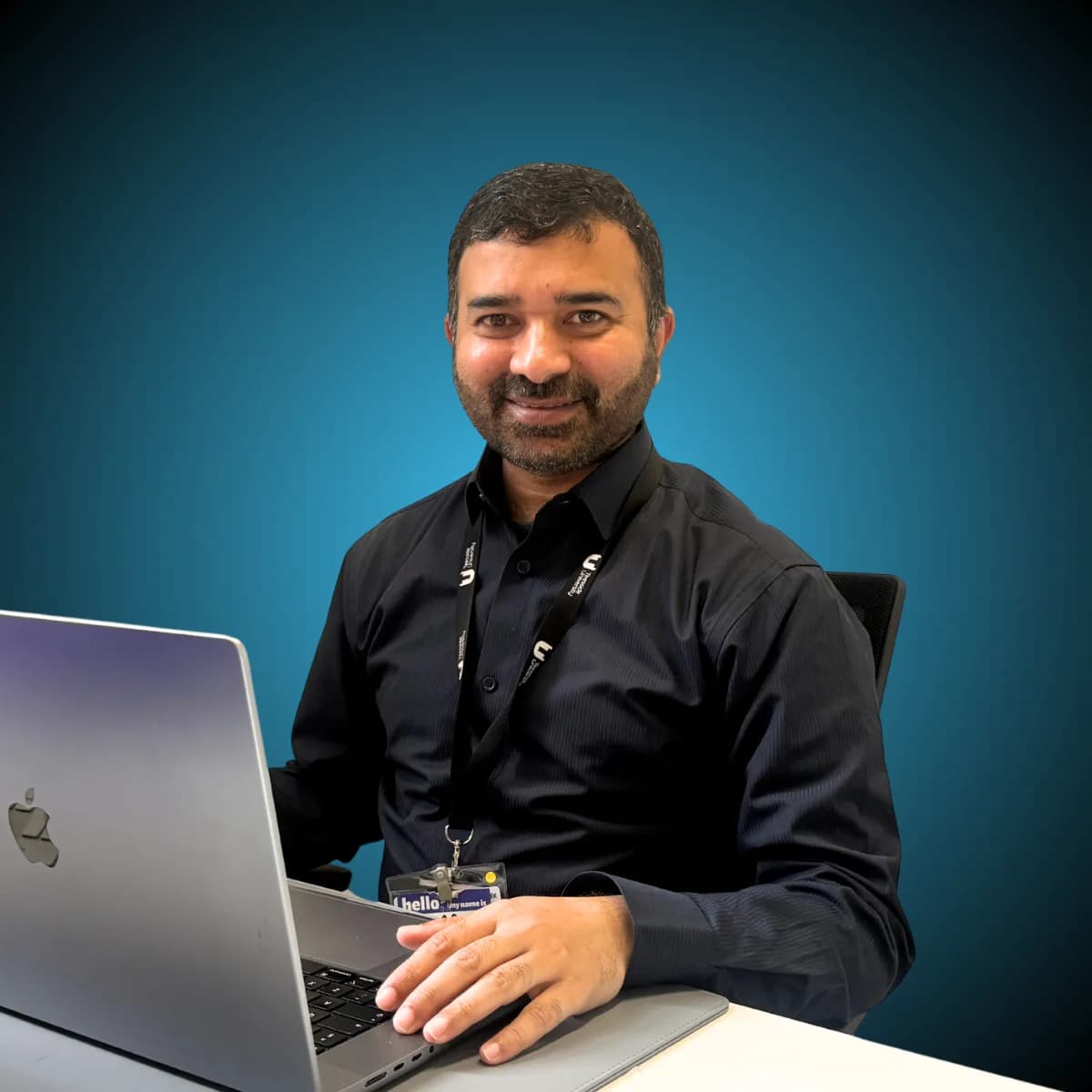 Anwar Malik at his desk with a laptop
